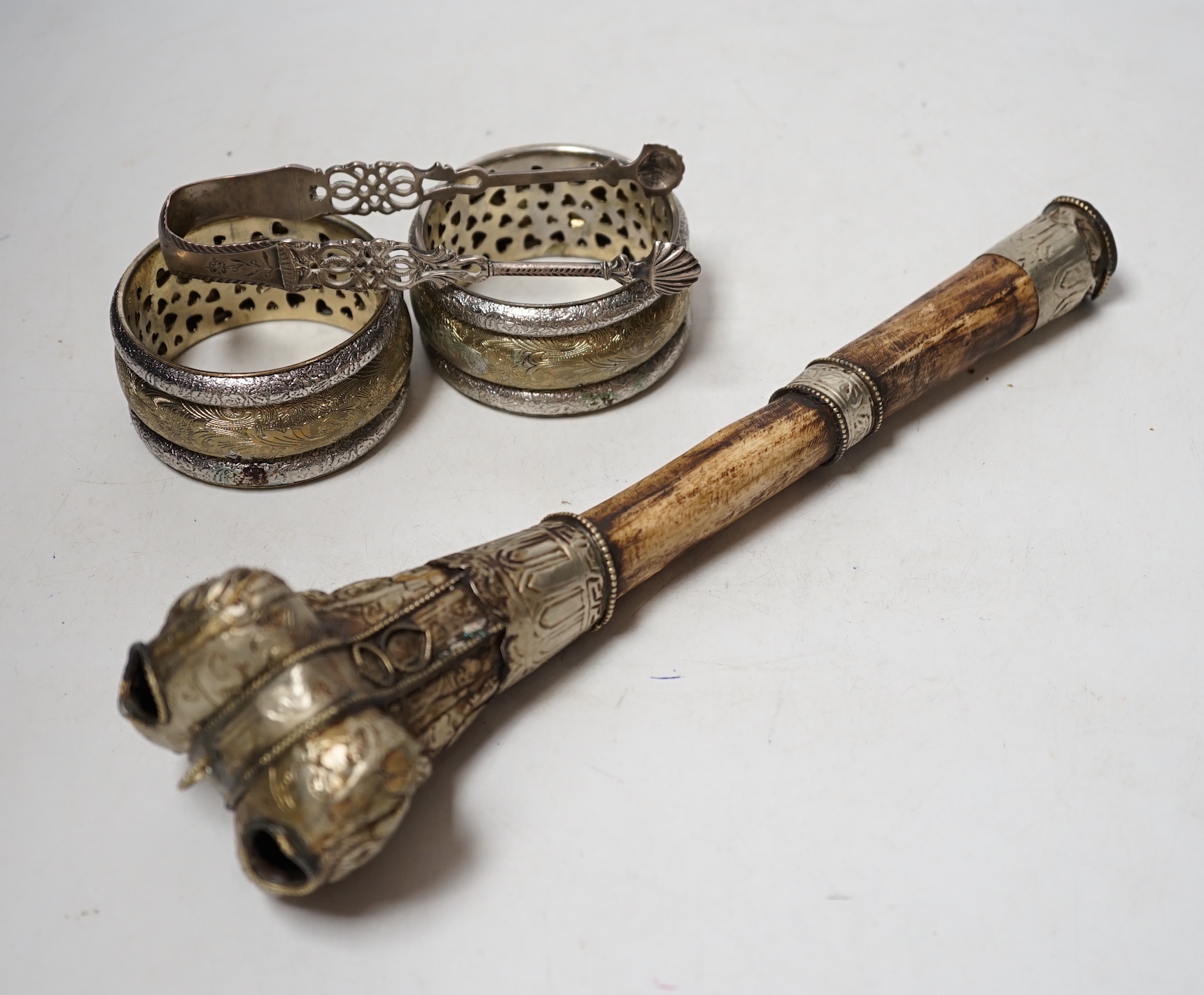 A pair of Georgian silver sugar tongs, a mounted bone implement and a pair of mixed metal bangles.